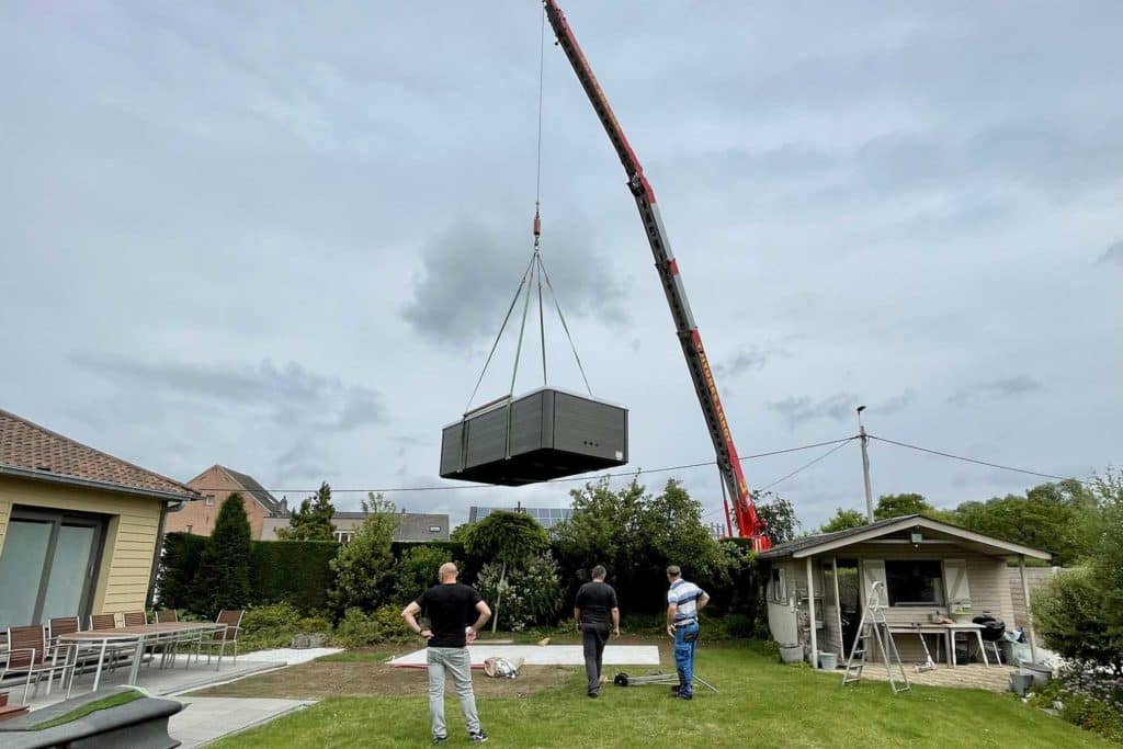 Grue plaçant un jacuzzi dans un jardin